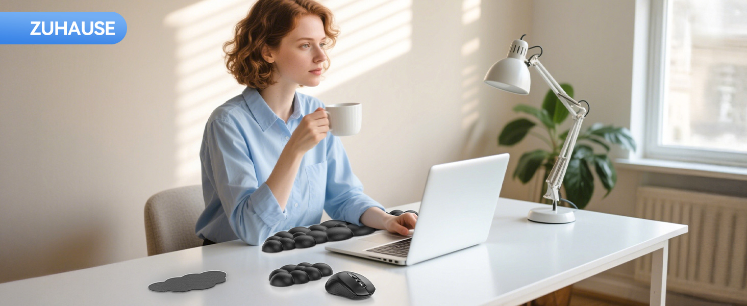 Person, die ihren Laptop am Schreibtisch in der Nähe des Fensters mit Zimmerpflanze benutzt und eine komfortable Heimbüro- oder Fernarbeitsumgebung zeigt.