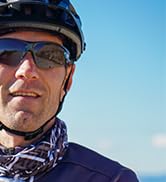 Collage of someone wearing sunglasses in outdoor settings, showing different angles and poses against blue sky backgrounds.