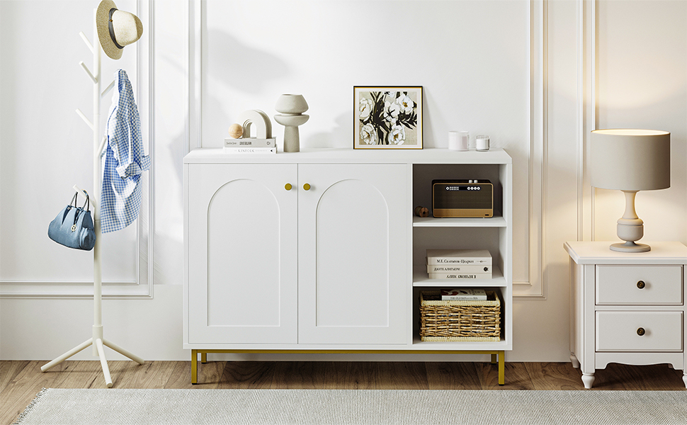 White storage cabinet with gold handles, open shelves, and closed compartments. Styled in a bright room with accessories and decor items.