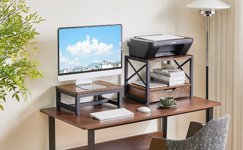 Configuration de bureau à domicile avec bureau en bois, écran d'ordinateur affichant le paysage urbain, imprimante sur une étagère au-dessus. Chaise et plante visibles sur la scène.