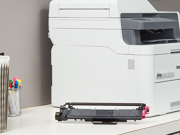 TN223M Toner Cartridge Next to Printer