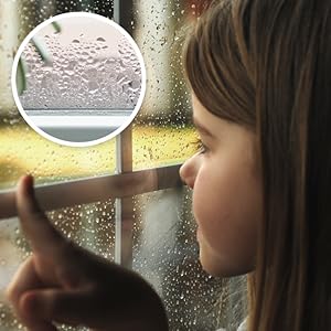 a child pointing at a window with condensation on it.