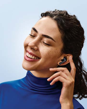 Soggetto che indossa auricolari wireless e dolcevita blu, mostrato di profilo durante l'ascolto dell'audio