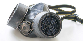 A gray charcoal filtered mask with adjustable strap attached