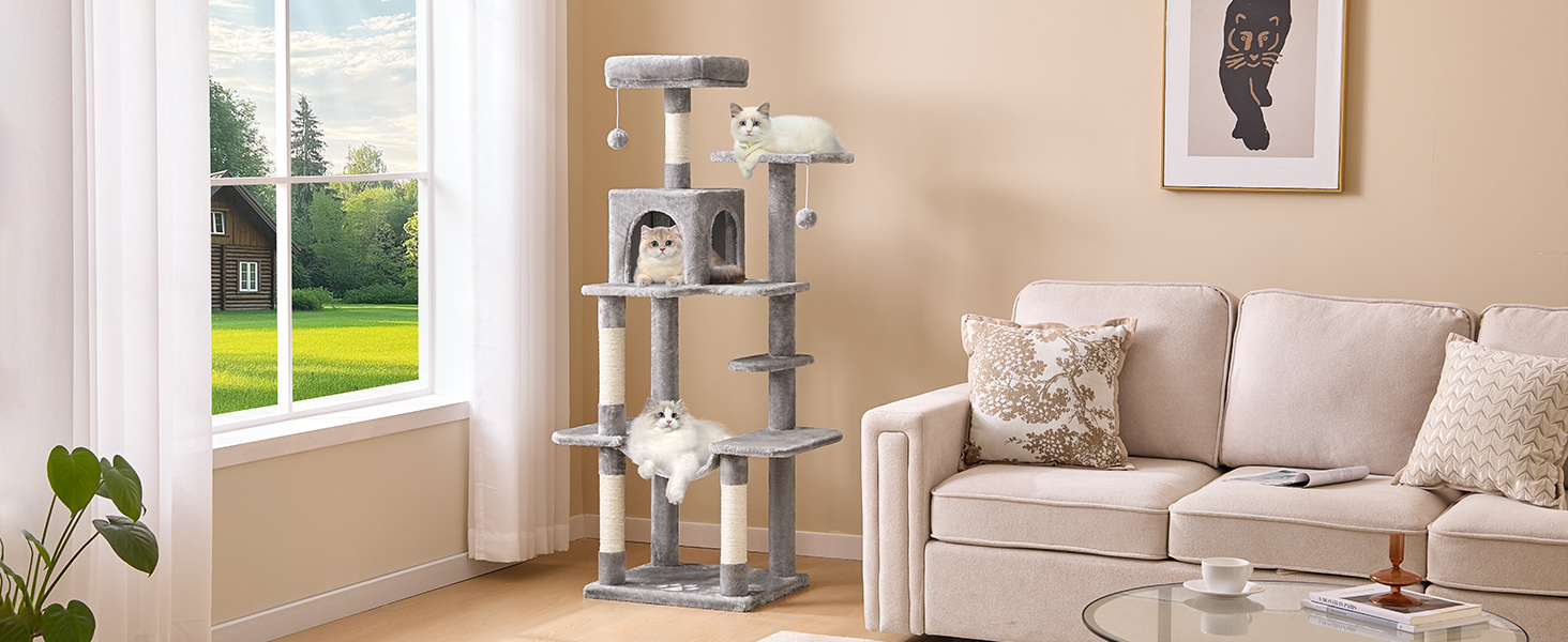 Mehrstöckes Katzenbaummöbel in Grauer Farbe Mit Plattformen, Kratzbäumen und Gemütschen Betten. Dargestell in Einer Wohntzimmerrichtung Neben Einem Sofa.