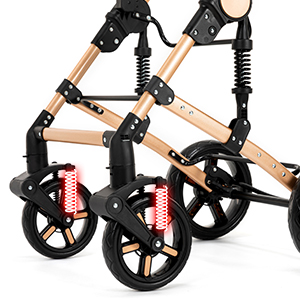 Close-up of wheelchair wheels and frame. Visible components include large black wheels, wooden armrests, metal joints, and red spring suspension system.
