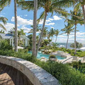 a pool in the floriday keys with lush flora from beyond the garden