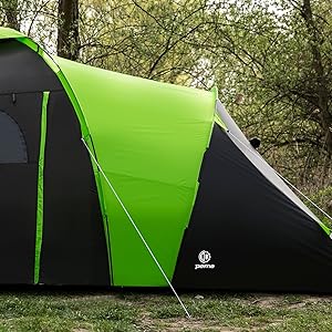 Gran tienda de campaña para exteriores en una combinación de colores verde y negro brillante, con varias secciones y ventanas de malla, instalada en un terreno cubierto de hierba