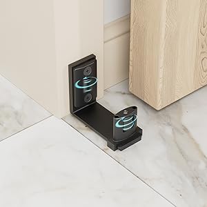 Türstopper aus schwarzem Metall mit blau beleuchteten Symbolen, montiert am Fuß einer Holztür auf hellem Bodenbelag