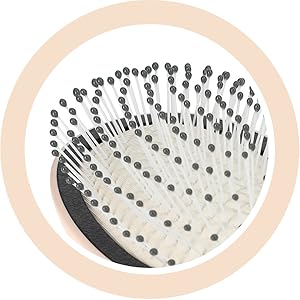 Brosse à cheveux circulaire avec manche de couleur claire. La tête de brosse comporte plusieurs rangées de poils disposés en spirale