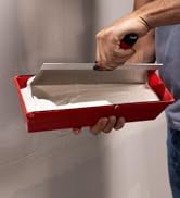 027-002 Plastic Mud Pan in a drywallers hand, being used to hold drywall mud