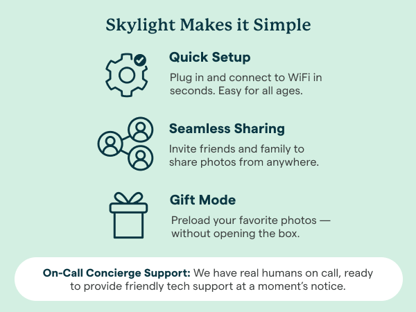 Skylight digital photo frame on table, with hand holding phone.
