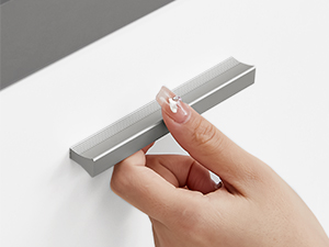 Közeli kép egy kézről, amely egy apró, téglalap alakú, ezüst felületű fémtárgyat, esetleg USB-meghajtót vagy kompakt elektronikus eszközt tart