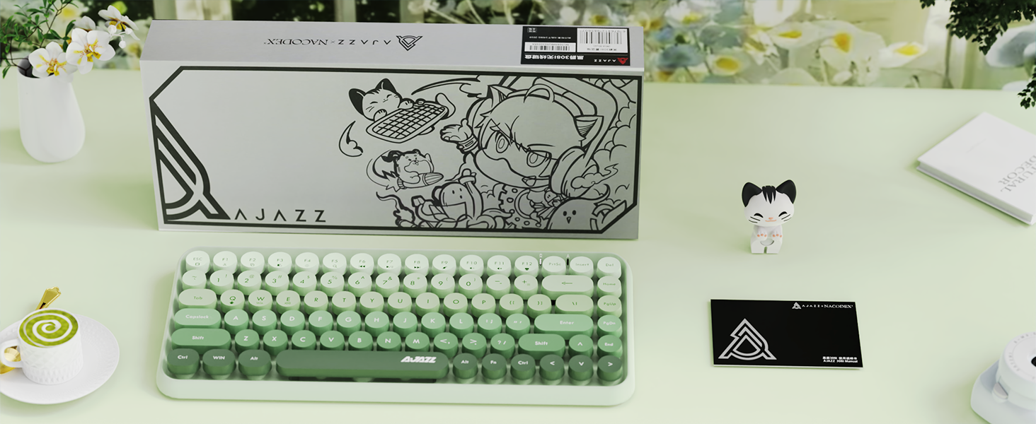 Compact mechanical keyboard in mint green color with white keycaps, displayed on a light desk surface alongside its decorative packaging box featuring artistic illustrations.