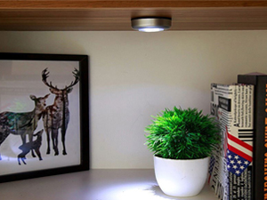 Push light being used to illuminate a shelf