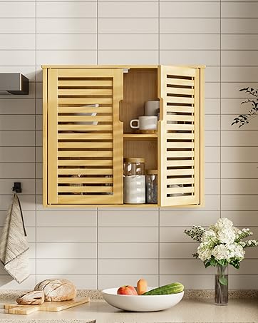 Wall-mounted bamboo bathroom cabinet with slatted doors, installed above white subway tiles. Decorative elements include fresh flowers in a bowl and hanging towel.