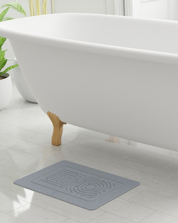 Absorbent stone bath mat in a spa-like setting, instantly drying water.
