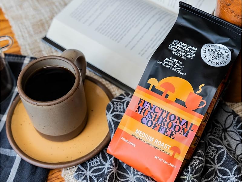 a bag of coffee, mug of coffee and open book in background