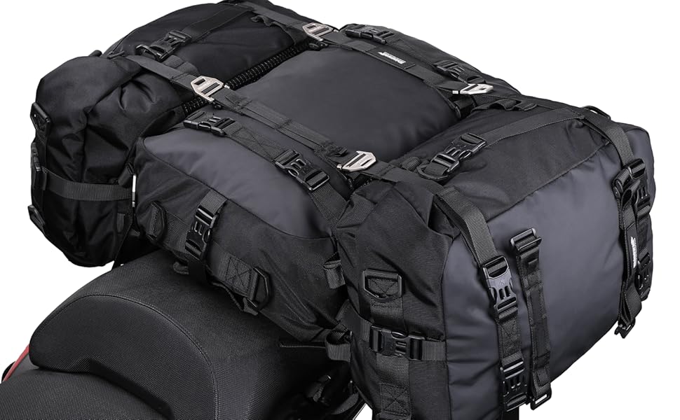 Large black motorcycle luggage bag with multiple straps and compartments, attached to a red motorcycle seat. Durable waterproof material with adjustable buckles for secure fastening.