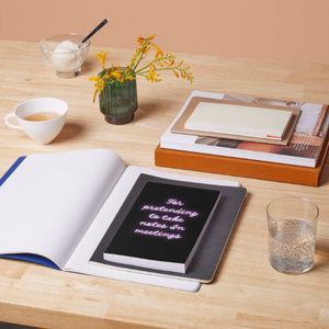 black and neon coloured notebook lying on top of another opened notebook