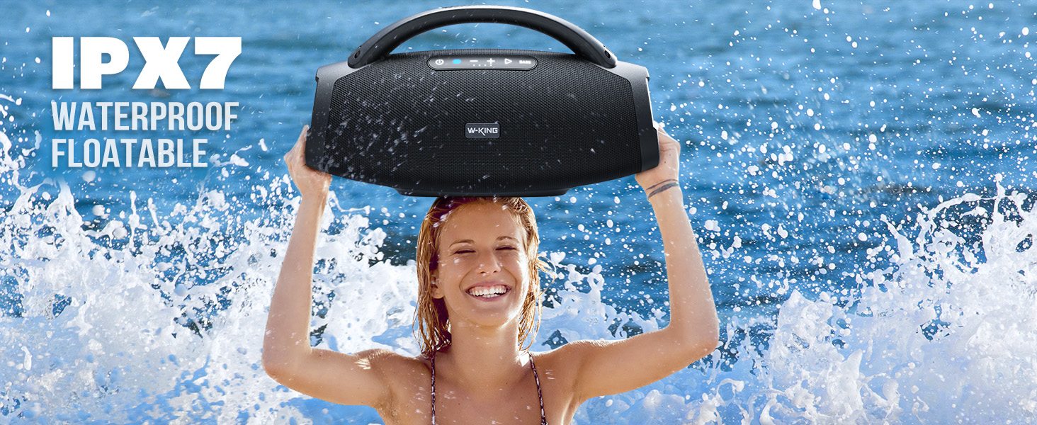 a woman holding a bluetooth speaker over her head.