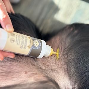 Soother & Moisturizer Application, bright yellow liquid squeezing out of bottle onto dog's belly