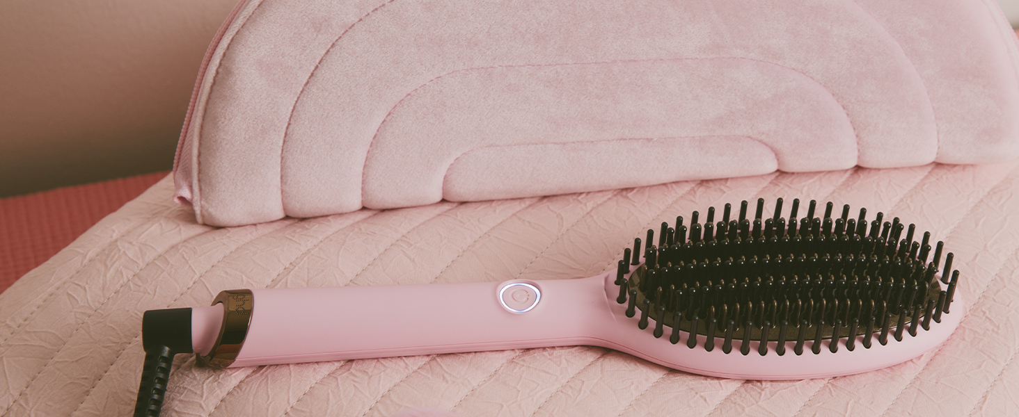 Cepillo de pelo con mango curvo que se muestra desde varios ángulos sobre un fondo rosa. El cepillo presenta cerdas oscuras en un diseño de cabeza ovalada.