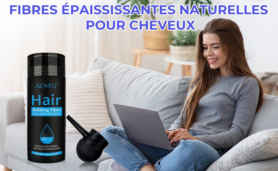 Flacon noir de fibres épaississantes pour cheveux à côté du pinceau d'application. L'étiquette du produit est visible avec le texte « Hair ». Femme utilisant un ordinateur portable sur un canapé en arrière-plan.