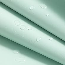Close-up of light green leather-like material with water droplets on its surface, showcasing a water-resistant or waterproof property. The texture appears smooth with a subtle grain.