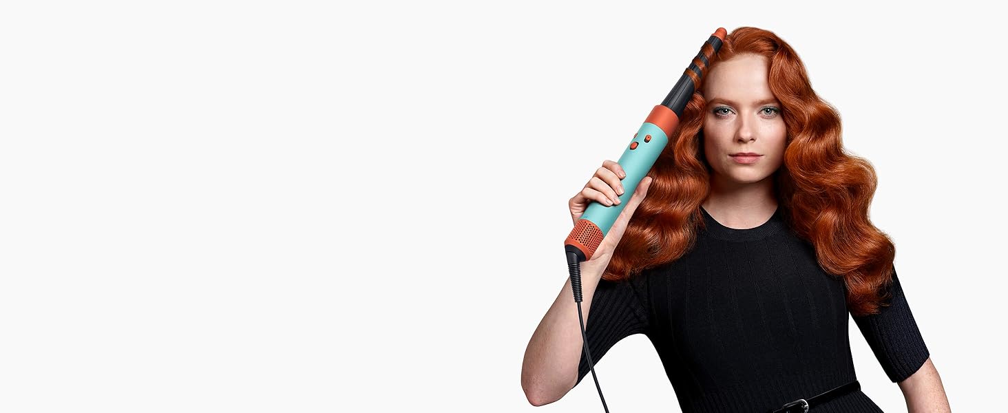 Ein Model mit rotem Haar verwendet den konischen Airwrap Lockenaufsatz, um ihre Haar zu wellen.