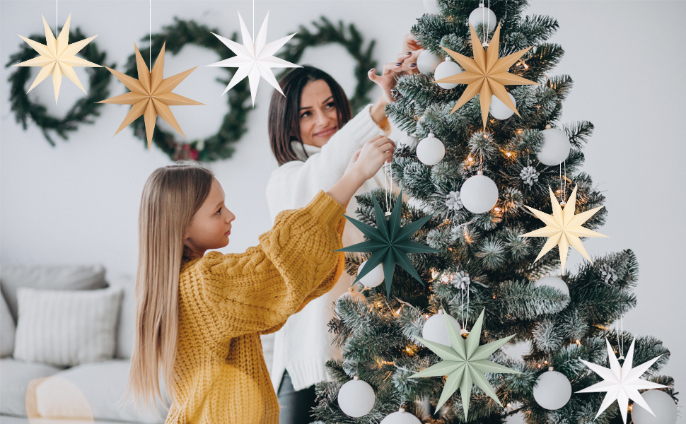 a mother and daughter decorating a christmas tree