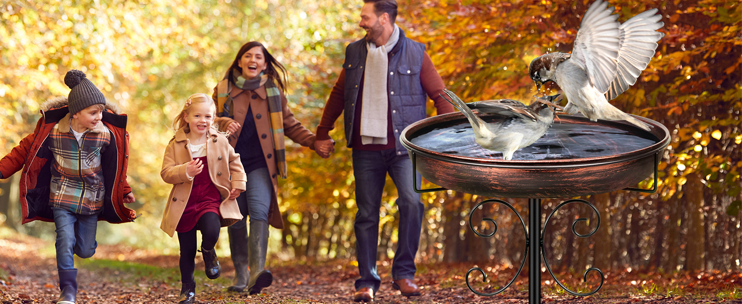 Outdoor-Szene mit Familie, die im Herbst in der Nähe eines Vogelhäuschens spazieren geht und aktiven Lebensstil und Interaktion mit der Natur zeigt