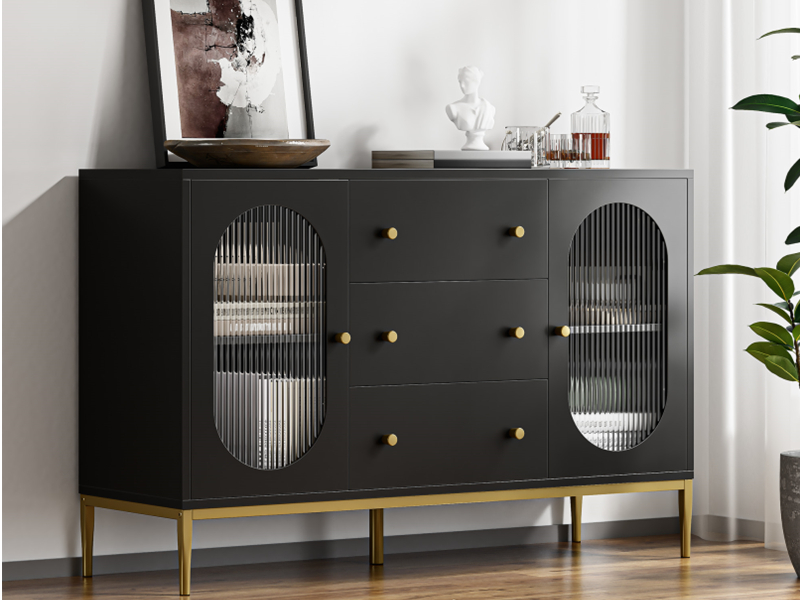 Modernes schwarzes Sideboard mit gerippten Glasscheibentüren, drei Schubladen mit Messingknöpfen und goldfarbenem Metallsockel. Dekorative Gegenstände