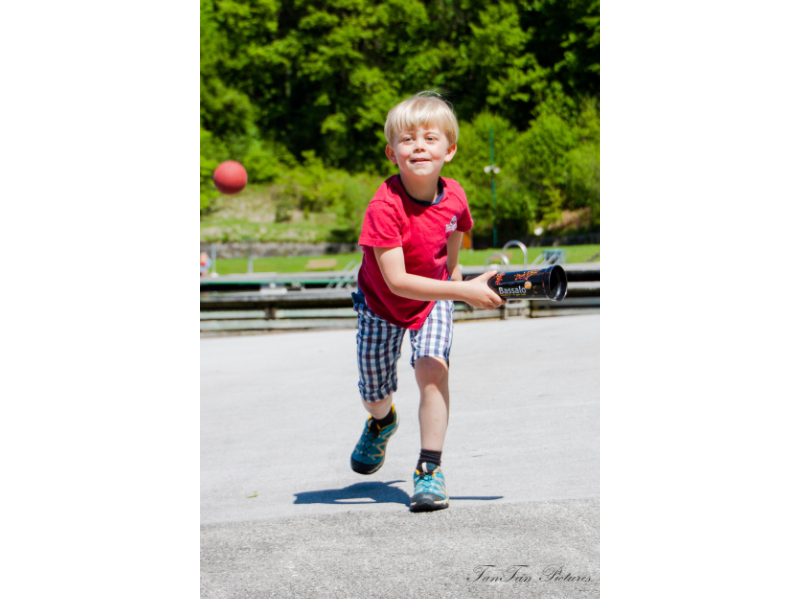 Kind läuft mit becher in der Hand hinter Bassalo Ball