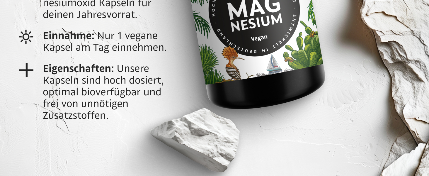 Magnesiumergänzungsflasche mit der Aufschrift „MAG NESIUM“ auf weißem Hintergrund mit Steinen. Der Text beschreibt vegane Kapseln, hohe Dosierung, Bioverfügbarkeit und keine unnötigen Zusatzstoffe