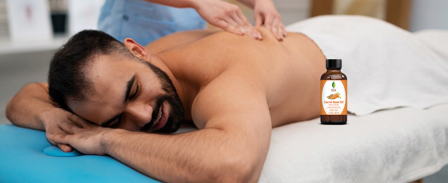 A person receiving massage using carrot seed carrier oil from amber glass bottle for body care