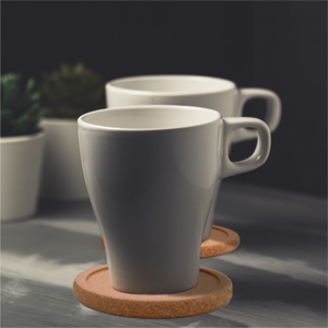 Two grey cups rest on two cork coasters.