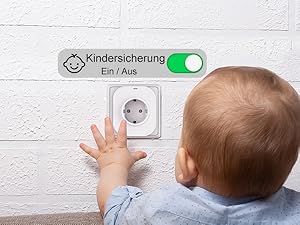 Der Text lautet „Kindersicherung Ein/Aus“. Steckdose mit Kindersicherung und Kippschalter, nach der die Hand reicht.