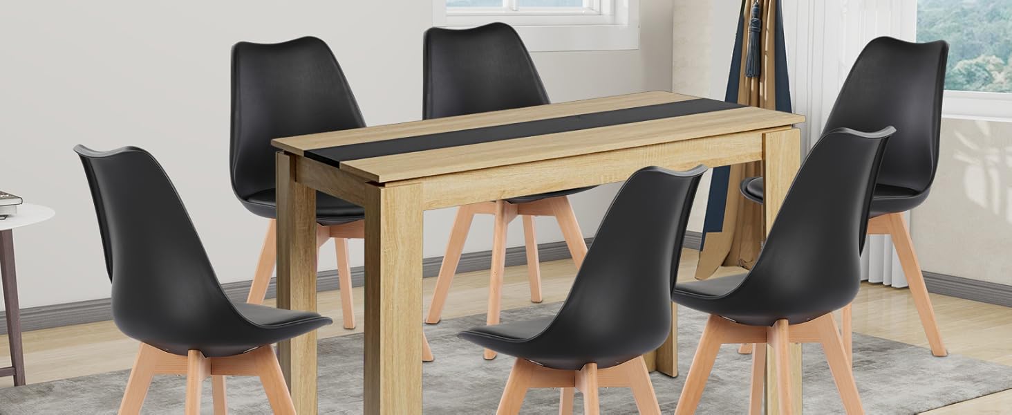 Moderne Essgruppe mit Holztisch mit schwarzer Intarsie. Sechs schwarze, geformte Stühle mit Holzbeinen. Auf einem grauen Teppich in einem hellen Raum mit Fenster und Kunstwerken.