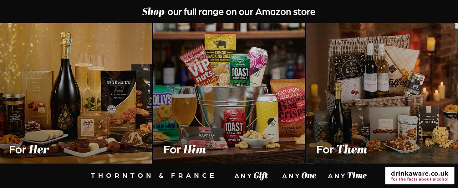 Gift basket collection featuring wine bottles, snacks, and food items arranged on wooden shelves. Products include crackers, chocolates, and gourmet treats.