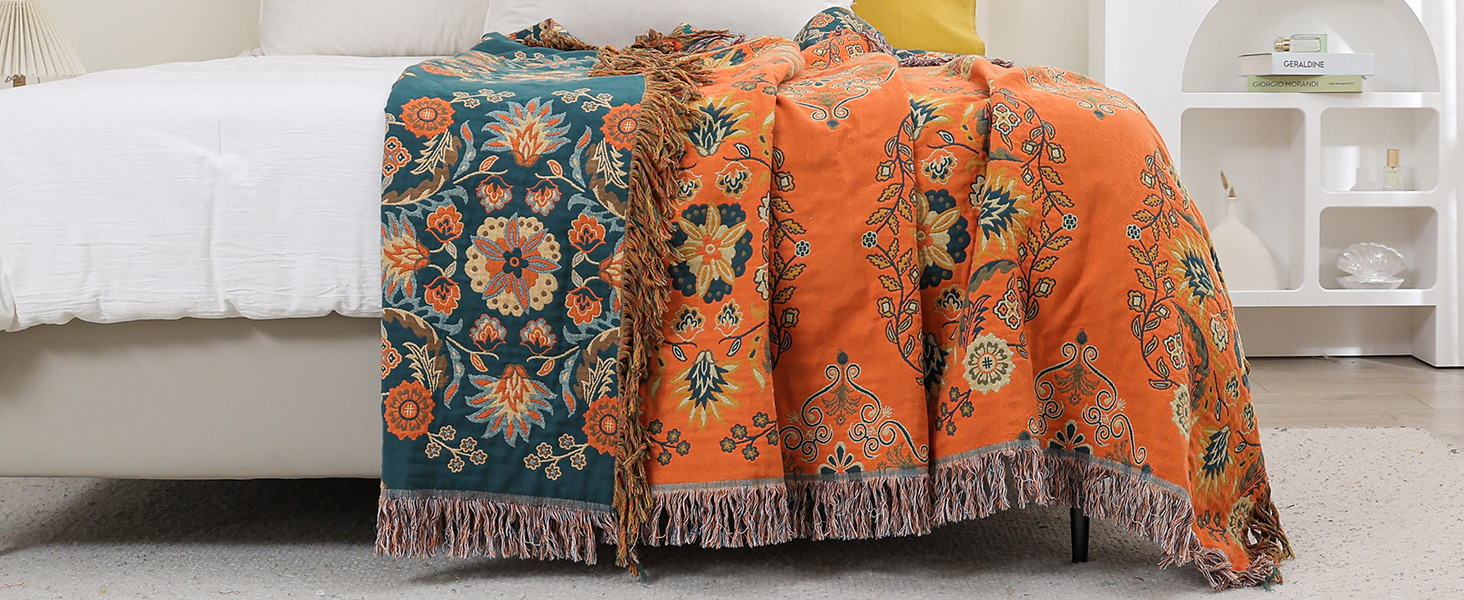 a pair of orange and blue velvet pillows with fringes