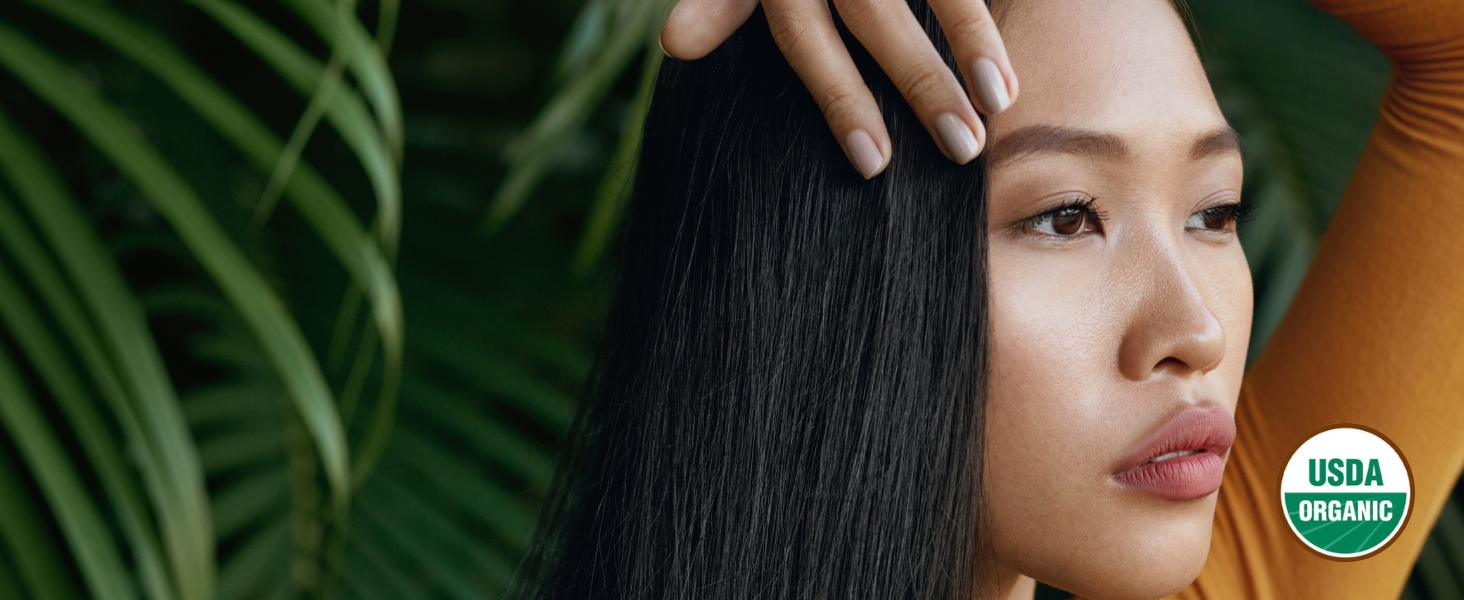 Close-up of a contemplative woman with flawless skin and shiny black hair