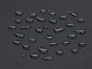 Vízcseppek közeli felvétele sötét, sima felületen. A cseppek mérete változó, és szétszórva helyezkednek el a képen, ami vízlepergető tulajdonságokat mutat.