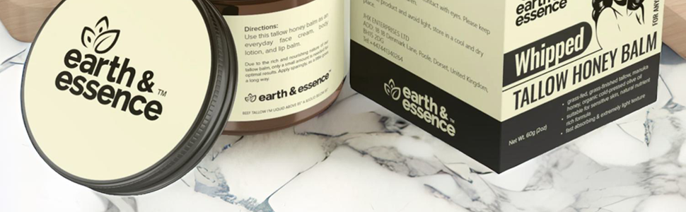 Earth & Essence branded skincare products including a round container and box labeled 'Tallow Honey Balm' displayed on marble surface.