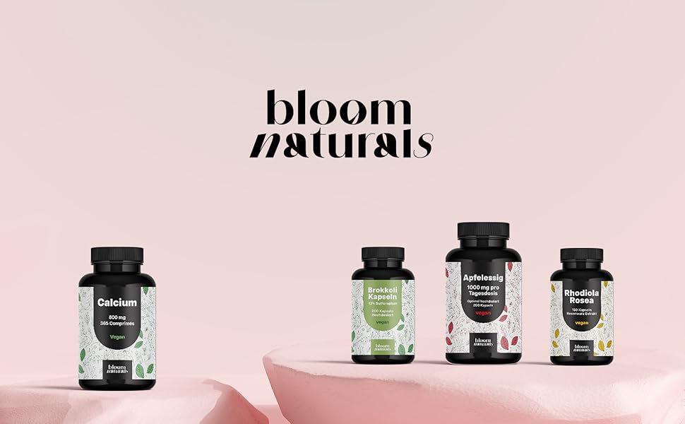Le texte indique « BIOFIT NATURALS ». Collection de flacons noirs de suppléments ou de vitamines avec des étiquettes blanches, affichés en ligne sur fond rose.