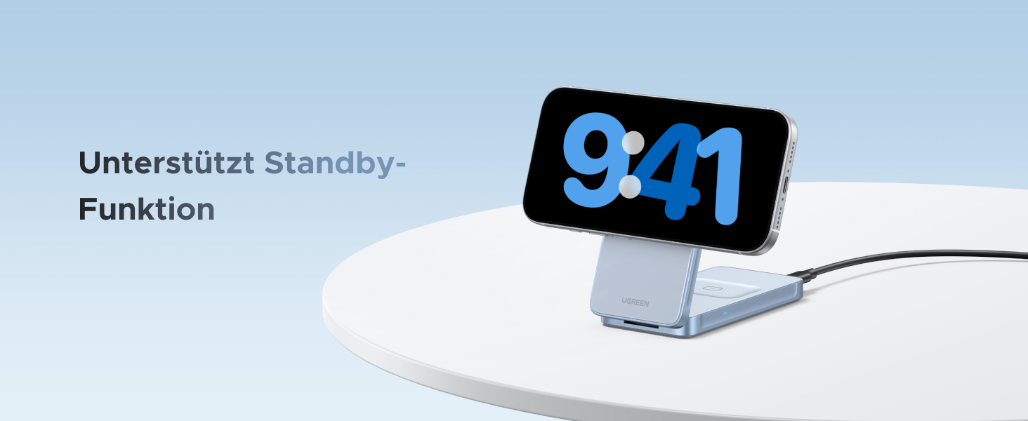 Der Text lautet „Unterstützt Standby-Funktion“. Das Produktfoto zeigt ein weißes elektronisches Gerät mit Smartphone-Ladefunktion vor hellblauem Hintergrund.