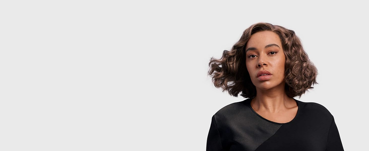 A model with her naturally coily hair styled into cloud curls.