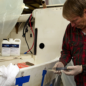 Using a syringe to inject TotalBoat clear Penetrating Epoxy sealer to rebuild rotted wood