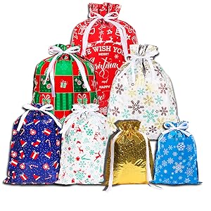 Collection of festive gift bags in various sizes featuring snowflake patterns, Christmas designs in red, blue, and white colors with holiday motifs.