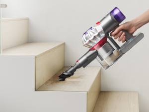 Aspiradora de mano Dyson Car+Boat limpiando escaleras con el accesorio multifunción.